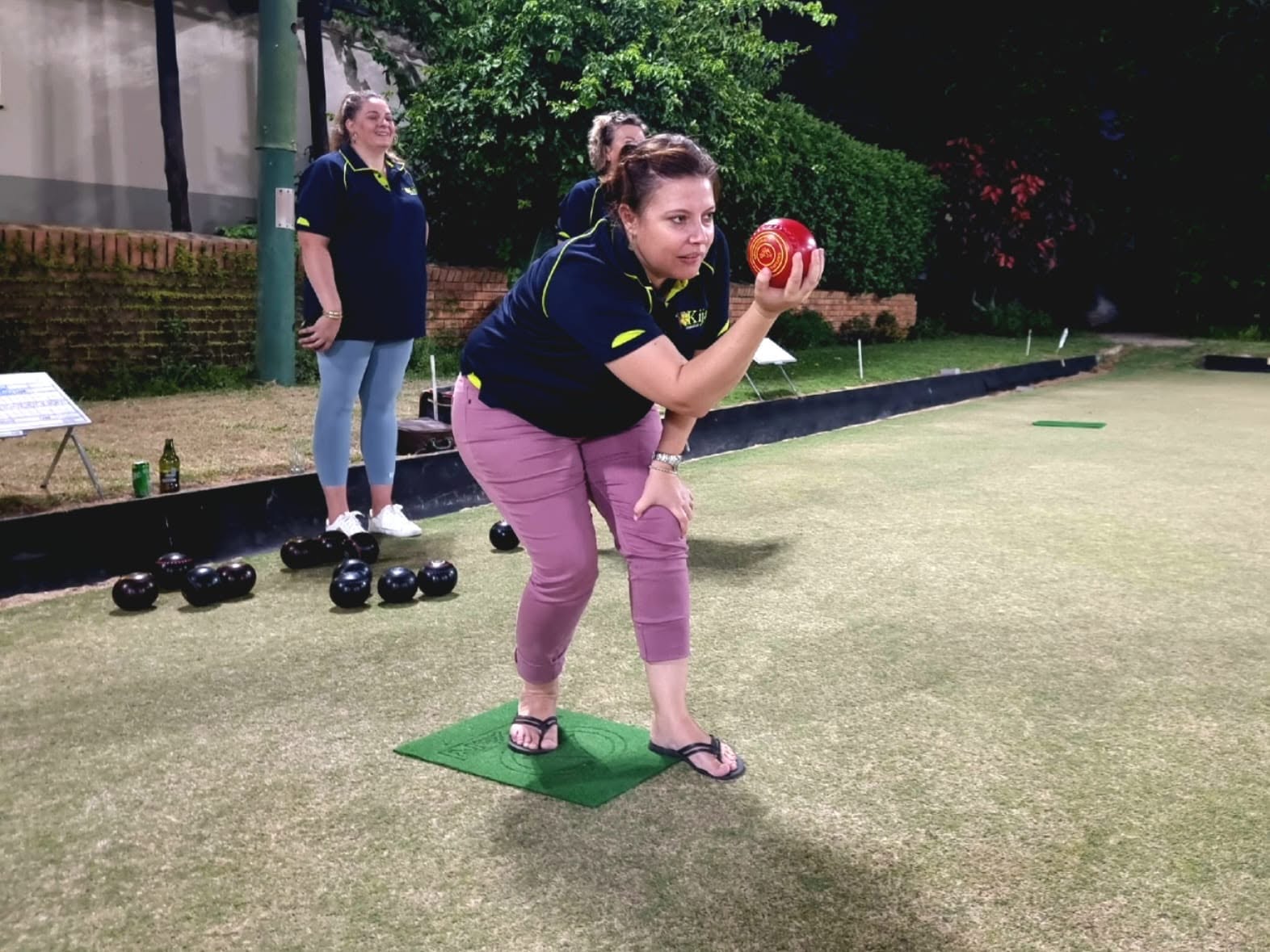 A bowls player lining up a shot