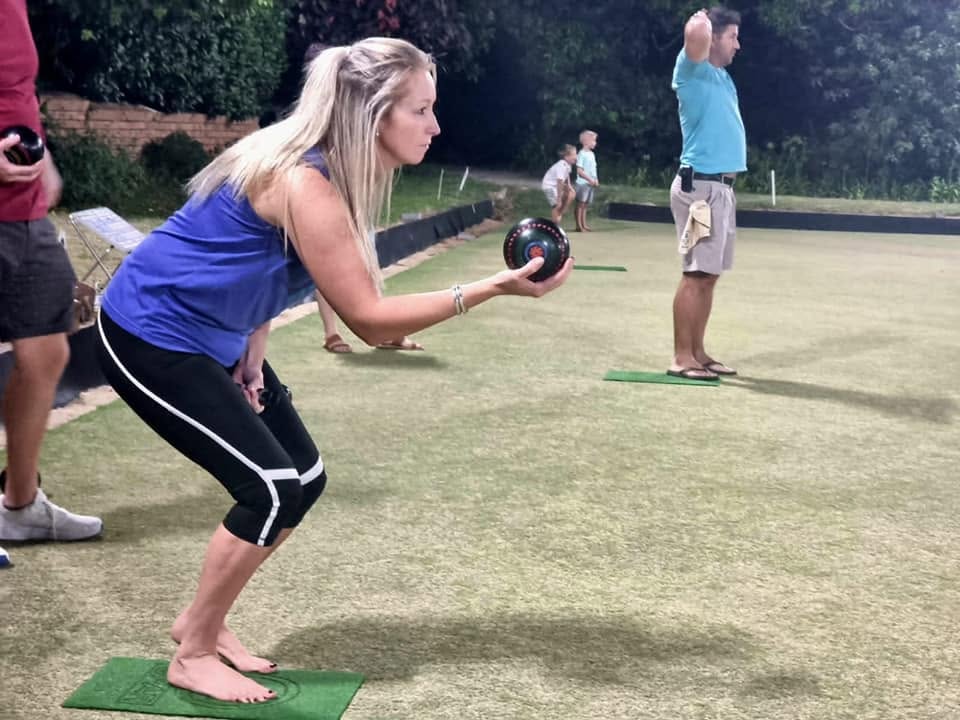 A player rolling a bowl toward the jack