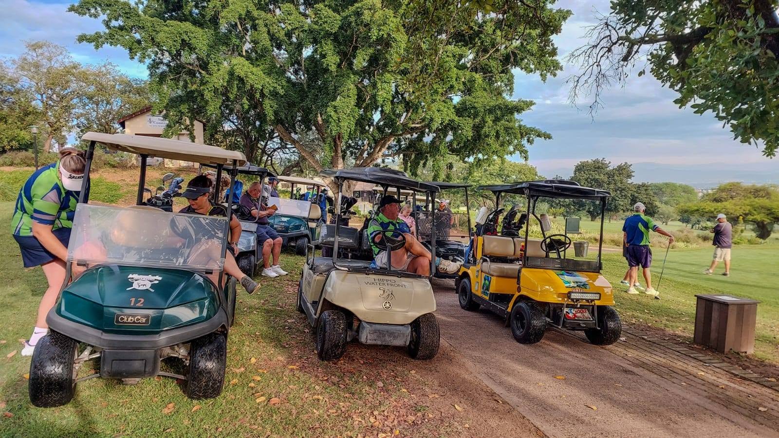Kijat golfers and their carts gathered on the course