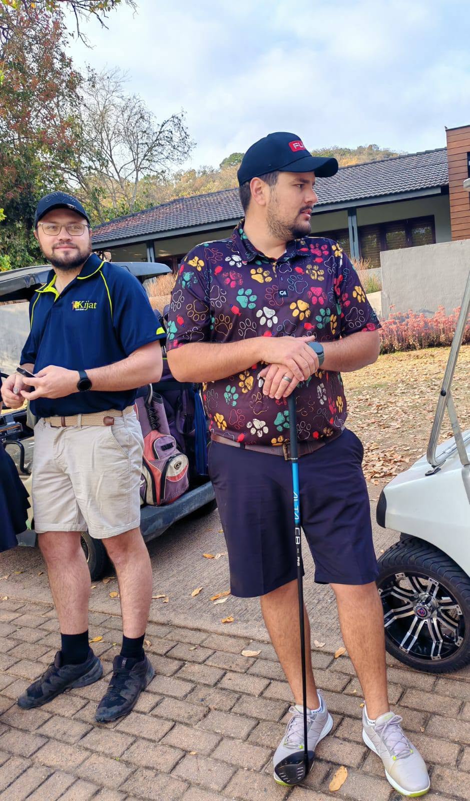 Two club members chatting beside a golf cart